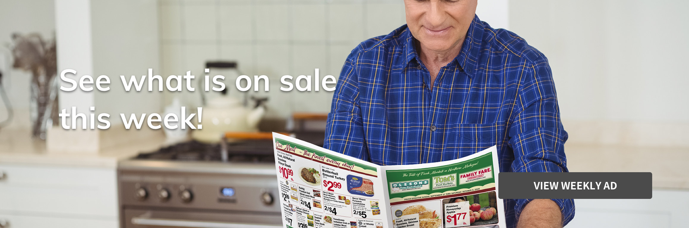 Man reading weekly ad in a kitchen.